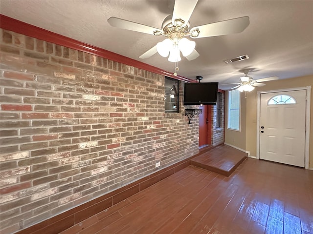 113 Fm 3454th Rd, Huntsville, TX 77320 - entrance foyer featuring ceiling fan, brick wall, dark wood-style flooring, and baseboards