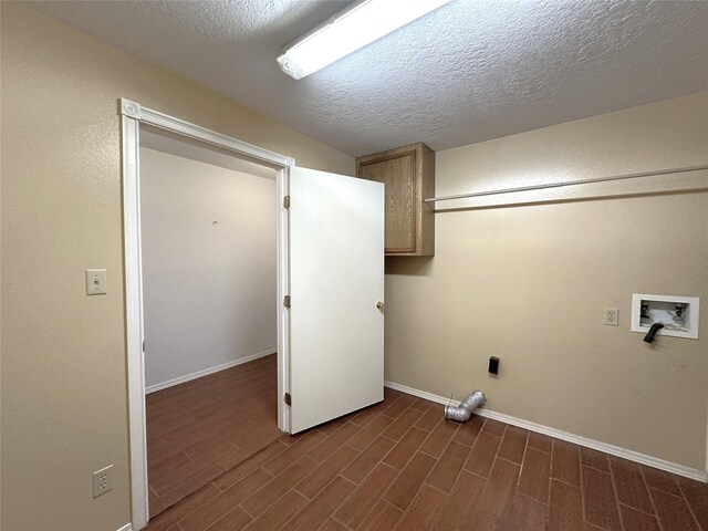 113 Fm 3454th Rd, Huntsville, TX 77320 - laundry area featuring cabinet space, hookup for a washing machine, dark wood finished floors, a textured ceiling, and baseboards
