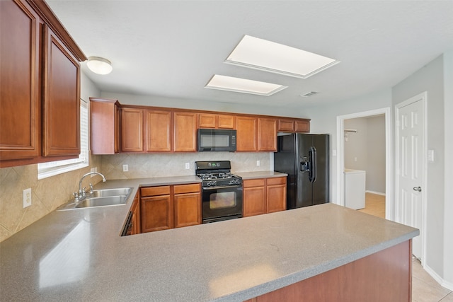 6419 Bonnie Chase Ln, Katy, TX 77449 - kitchen with black appliances, washer / clothes dryer, tasteful backsplash, a sink, and a peninsula