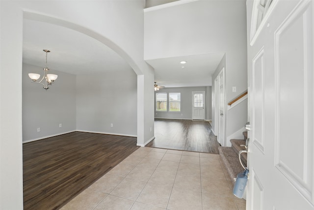 6419 Bonnie Chase Ln, Katy, TX 77449 - entrance foyer featuring wood finished floors, arched walkways, a chandelier, stairway, and a towering ceiling