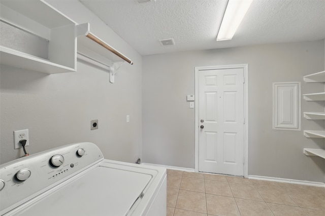 6419 Bonnie Chase Ln, Katy, TX 77449 - laundry room with washer / dryer, light tile patterned floors, a textured ceiling, and baseboards
