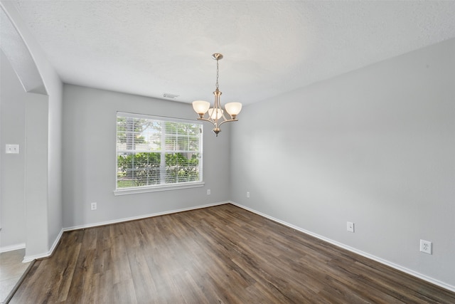 6419 Bonnie Chase Ln, Katy, TX 77449 - empty room with a chandelier, dark wood-style floors, baseboards, and arched walkways