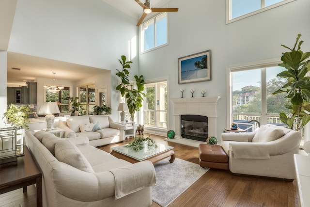 4315 Lago Viento, Austin, TX 78734 - living room featuring a towering ceiling, a glass covered fireplace, dark wood finished floors, and a ceiling fan