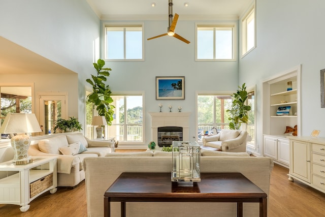 4315 Lago Viento, Austin, TX 78734 - living room with a high ceiling, ceiling fan, a fireplace, ornamental molding, and healthy amount of natural light