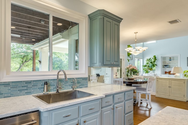 4315 Lago Viento, Austin, TX 78734 - kitchen featuring a sink, dishwasher, decorative backsplash, a chandelier, and wood finished floors