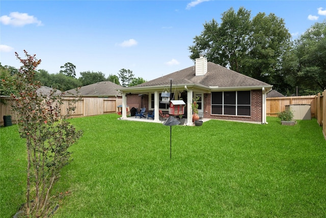 23 Drifting Shadows Cir, Conroe, TX 77385 - rear view of house featuring a patio area, a chimney, brick siding, and a shingled roof