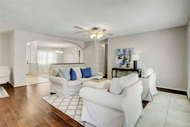 9327 Fairdale Ln, Houston, TX 77063 - living area with arched walkways, a chandelier, ceiling fan, wood finished floors, and baseboards