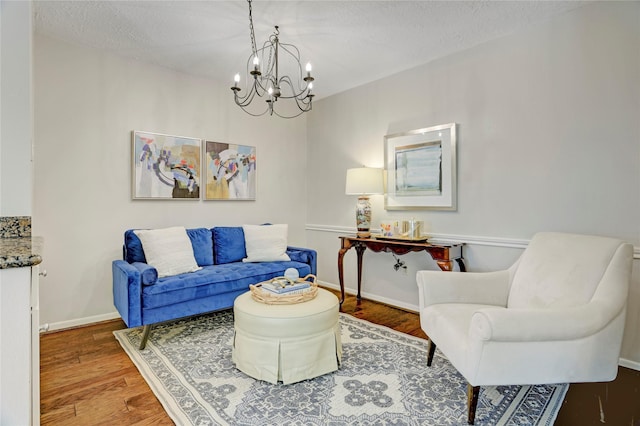 9327 Fairdale Ln, Houston, TX 77063 - living room featuring wood finished floors, a chandelier, a textured ceiling, and baseboards