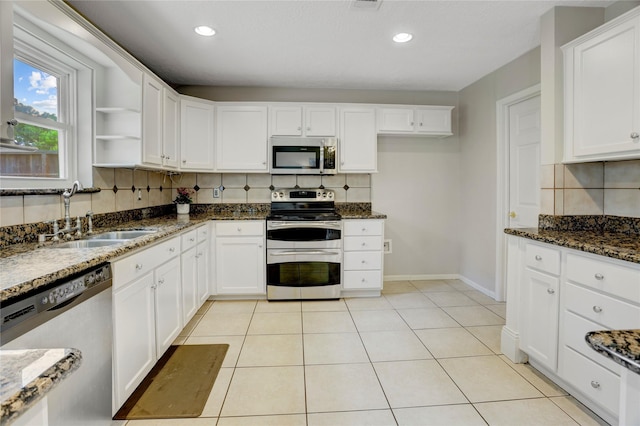 9327 Fairdale Ln, Houston, TX 77063 - kitchen featuring stainless steel appliances, a sink, decorative backsplash, white cabinets, and dark stone countertops