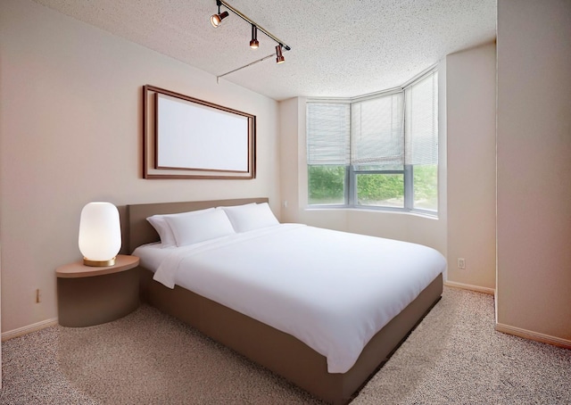 651 Bering Dr Unit 1101, Houston, TX 77057 - carpeted bedroom featuring a textured ceiling, baseboards, and rail lighting