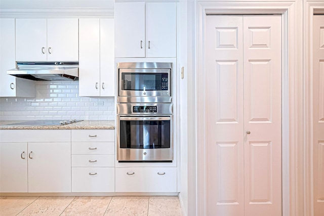 651 Bering Dr Unit 1101, Houston, TX 77057 - kitchen featuring appliances with stainless steel finishes, under cabinet range hood, backsplash, white cabinetry, and light tile patterned floors