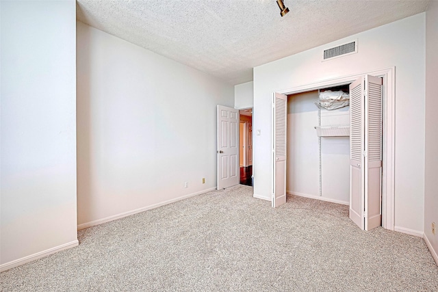 651 Bering Dr Unit 1101, Houston, TX 77057 - unfurnished bedroom featuring carpet floors, a closet, a textured ceiling, and baseboards