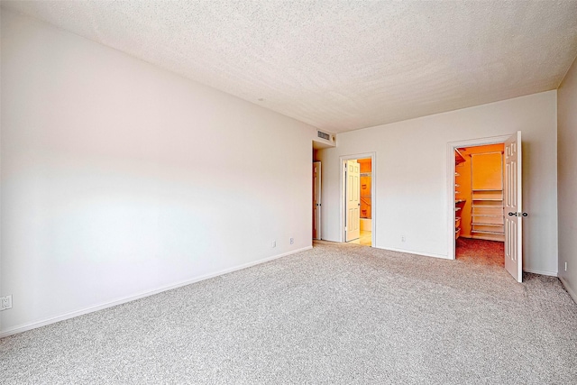 651 Bering Dr Unit 1101, Houston, TX 77057 - unfurnished bedroom with a spacious closet, light carpet, baseboards, a closet, and a textured ceiling