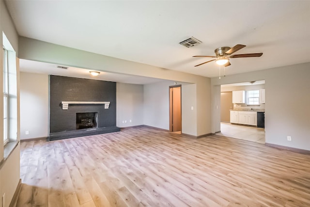 3313 Chestershire Dr, Pasadena, TX 77503 - unfurnished living room with light wood finished floors, a ceiling fan, a brick fireplace, and a sink