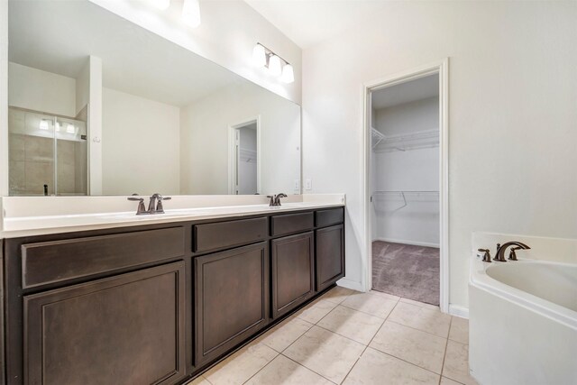 21114 Echo Manor Dr, Hockley, TX 77447 - full bathroom with double vanity, tile patterned flooring, a walk in closet, a garden tub, and a stall shower