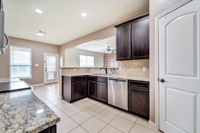 21114 Echo Manor Dr, Hockley, TX 77447 - kitchen with dishwasher, dark brown cabinetry, a peninsula, tasteful backsplash, and light tile patterned flooring