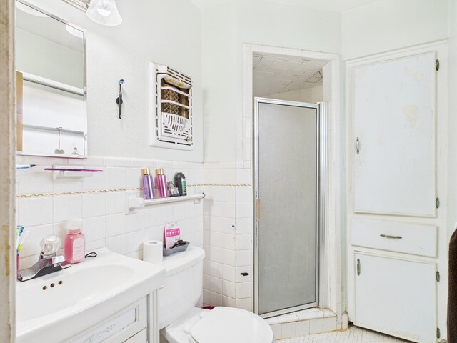 8206 Dillon St, Houston, TX 77061 - full bathroom with a shower stall, toilet, vanity, tile walls, and a wainscoted wall