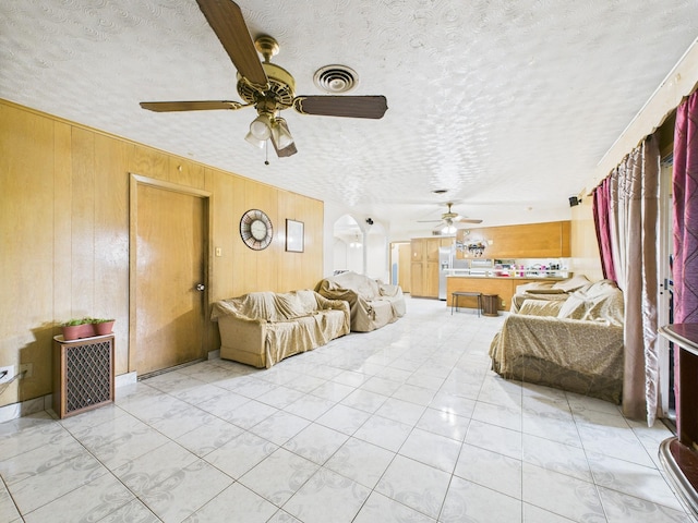 8206 Dillon St, Houston, TX 77061 - living area featuring a ceiling fan, wood walls, and a textured ceiling