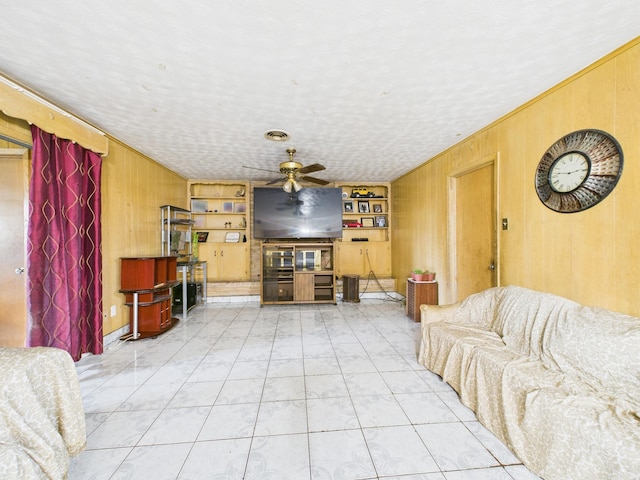 8206 Dillon St, Houston, TX 77061 - living room featuring wooden walls, a ceiling fan, and built in shelves