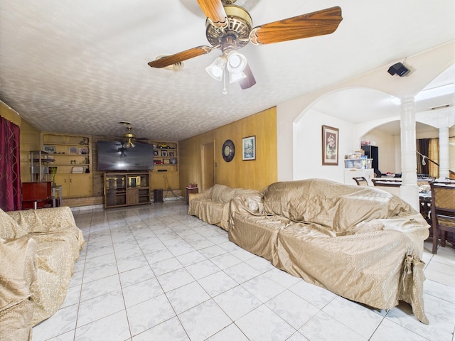 8206 Dillon St, Houston, TX 77061 - tiled living area with ornate columns, wood walls, ceiling fan, and arched walkways