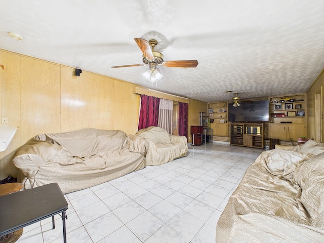 8206 Dillon St, Houston, TX 77061 - living room with a ceiling fan, wood walls, and tile patterned floors