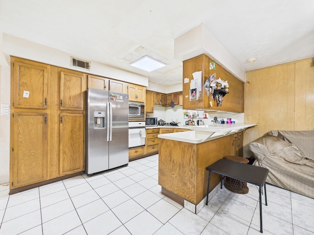 8206 Dillon St, Houston, TX 77061 - kitchen featuring stainless steel appliances, a peninsula, and brown cabinets