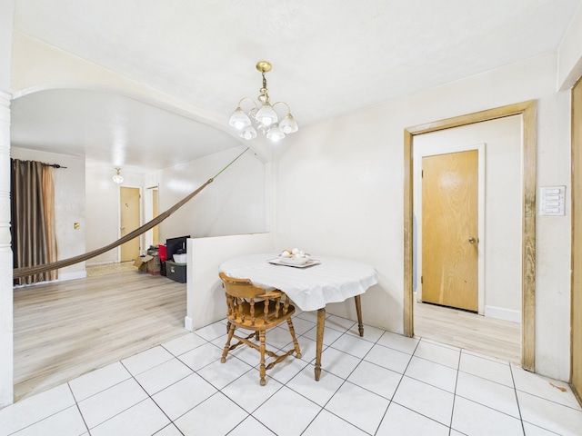 8206 Dillon St, Houston, TX 77061 - dining area featuring light tile patterned floors, a chandelier, and arched walkways