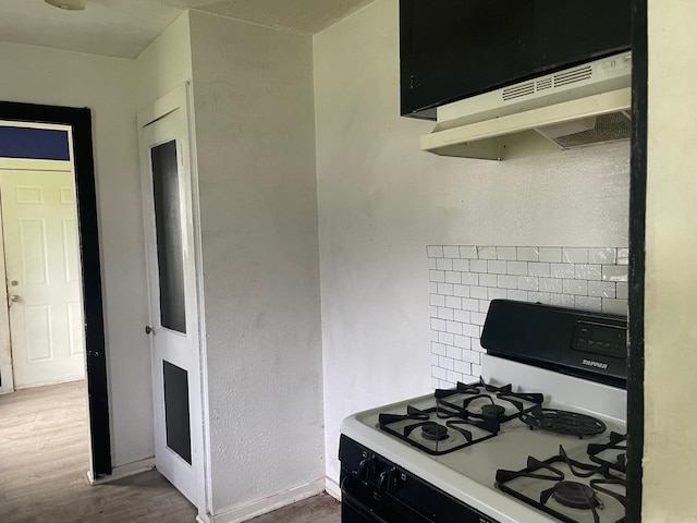 514 7th St, Humble, TX 77338 - kitchen with gas range, wood finished floors, and under cabinet range hood