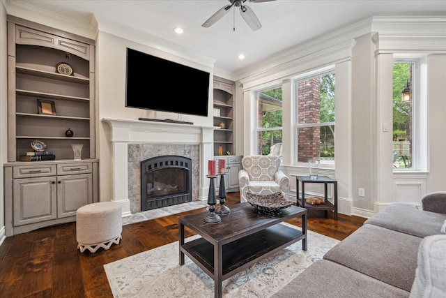 1902 Carriage Creek Ln, Friendswood, TX 77546 - living area featuring built in shelves, a ceiling fan, dark wood-style floors, ornamental molding, and a premium fireplace