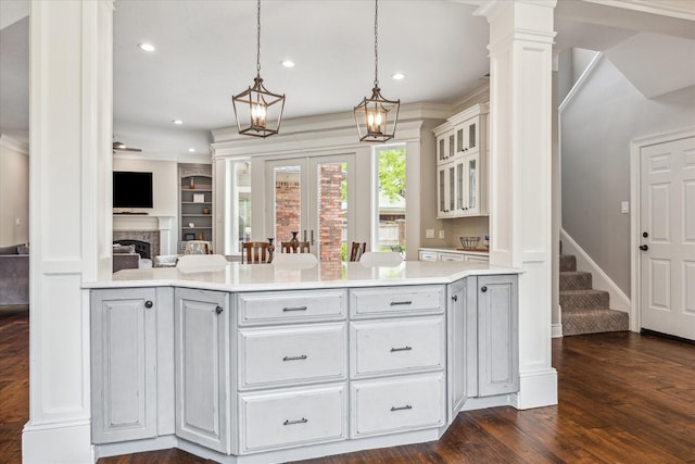 1902 Carriage Creek Ln, Friendswood, TX 77546 - kitchen featuring a peninsula, recessed lighting, dark wood-style flooring, glass insert cabinets, and light countertops