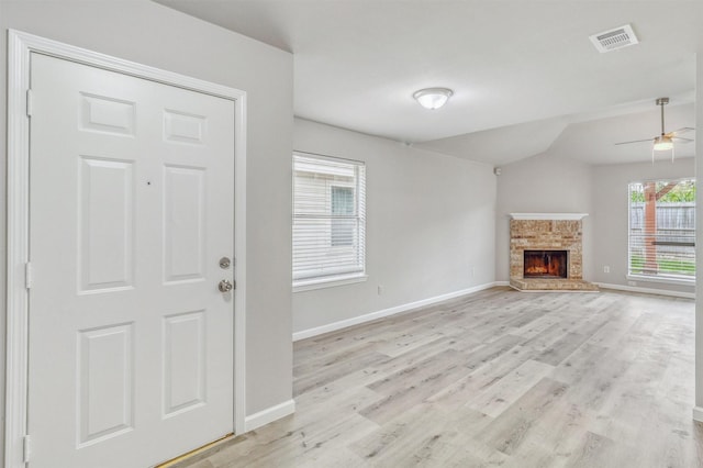 19822 Laurel Trail Dr, Cypress, TX 77433 - unfurnished living room with light wood-type flooring, baseboards, a warm lit fireplace, ceiling fan, and vaulted ceiling