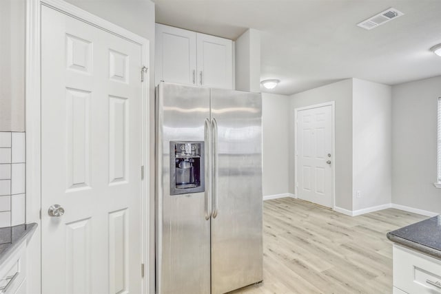 19822 Laurel Trail Dr, Cypress, TX 77433 - kitchen with stainless steel fridge, white cabinets, light wood-style flooring, baseboards, and dark stone countertops