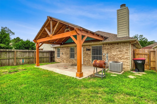 19822 Laurel Trail Dr, Cypress, TX 77433 - back of house featuring a chimney, brick siding, central AC, a patio, and roof with shingles