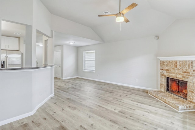 19822 Laurel Trail Dr, Cypress, TX 77433 - unfurnished living room with vaulted ceiling, light wood finished floors, ceiling fan, a fireplace, and baseboards