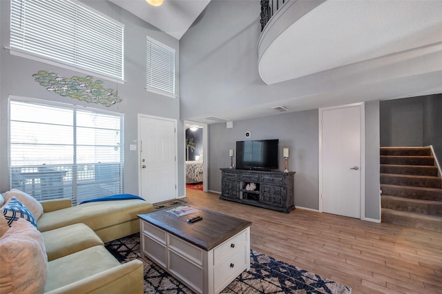 103 Jean Lafitte Cv, Galveston, TX 77554 - living room with stairway, light wood finished floors, baseboards, and a high ceiling
