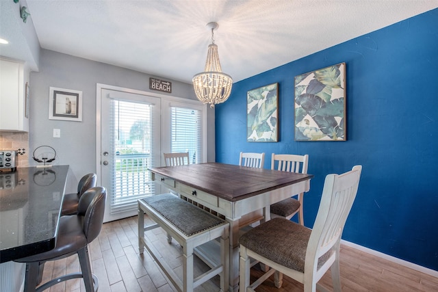 103 Jean Lafitte Cv, Galveston, TX 77554 - dining space featuring light wood finished floors, a chandelier, and baseboards