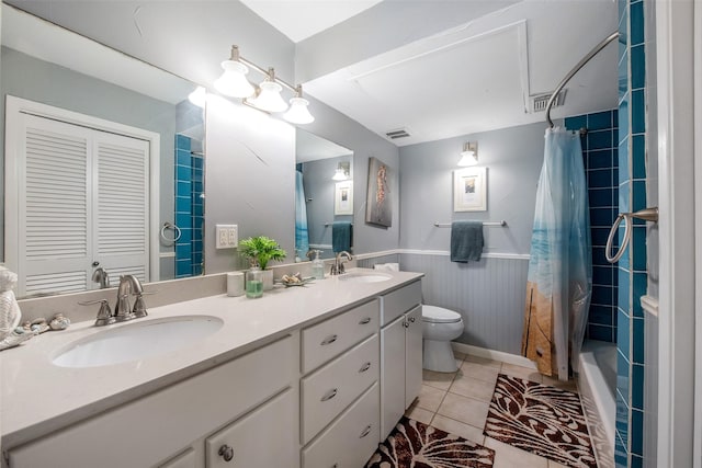 103 Jean Lafitte Cv, Galveston, TX 77554 - full bath with double vanity, toilet, wainscoting, tile patterned flooring, and shower / bath combo