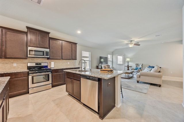 23715 Rivage Ridge Dr, Katy, TX 77493 - kitchen with appliances with stainless steel finishes, a sink, ceiling fan, dark brown cabinets, and backsplash