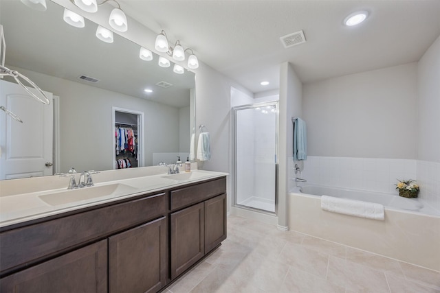 23715 Rivage Ridge Dr, Katy, TX 77493 - bathroom featuring a stall shower, a spacious closet, a bath, tile patterned floors, and double vanity