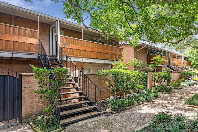 3944 W Alabama St Unit 12, Houston, TX 77027 - view of property exterior featuring stairs, brick siding, and a gate