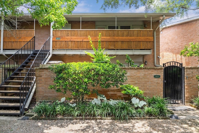 3944 W Alabama St Unit 12, Houston, TX 77027 - view of front of house featuring stairway, brick siding, a gate, and a balcony
