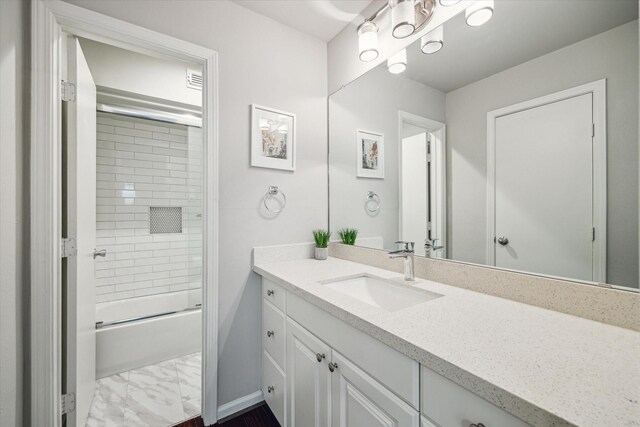 3944 W Alabama St Unit 12, Houston, TX 77027 - full bathroom featuring vanity, baseboards, bath / shower combo with glass door, and marble look tile flooring