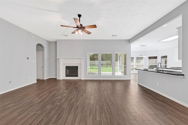 7818 Silver Lure Dr, Humble, TX 77346 - unfurnished living room with ceiling fan, dark wood finished floors, baseboards, and a fireplace