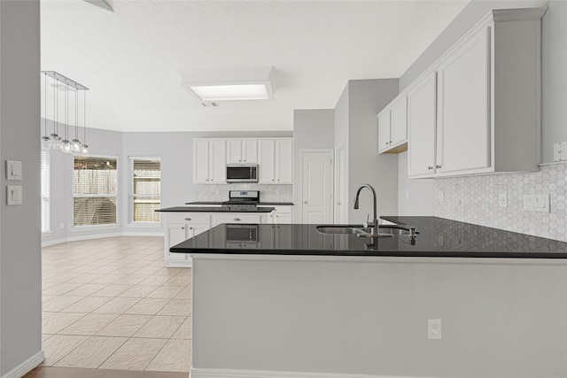 7818 Silver Lure Dr, Humble, TX 77346 - kitchen with stainless steel microwave, a sink, dark countertops, a peninsula, and tasteful backsplash