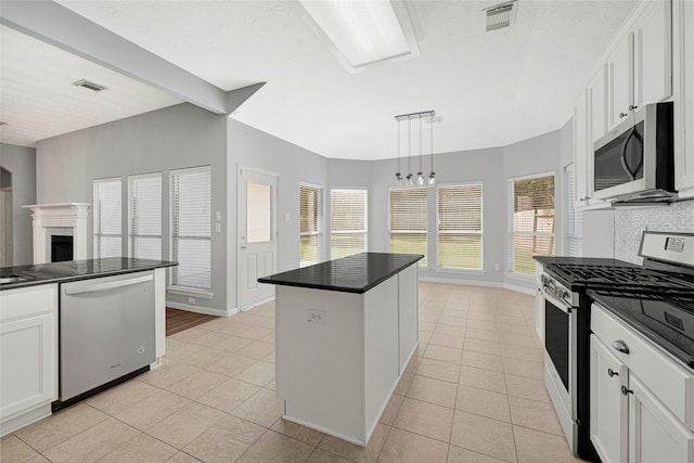 7818 Silver Lure Dr, Humble, TX 77346 - kitchen with stainless steel appliances, dark countertops, light tile patterned floors, and white cabinets