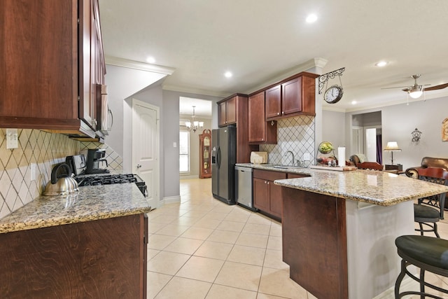 531 Private Road 6350, Dayton, TX 77535 - kitchen featuring stainless steel appliances, a breakfast bar area, a peninsula, ornamental molding, and decorative backsplash
