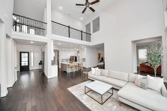 12813 N Palomino Lake Cir, Cypress, TX 77429 - living room with a high ceiling, a ceiling fan, dark wood-style floors, and baseboards
