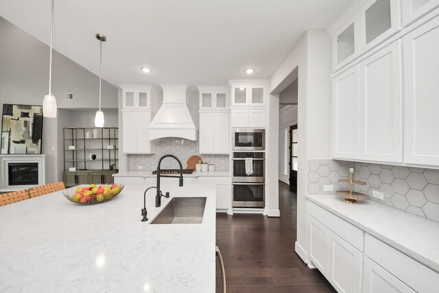 12813 N Palomino Lake Cir, Cypress, TX 77429 - kitchen with a sink, custom exhaust hood, stainless steel double oven, dark wood finished floors, and built in microwave