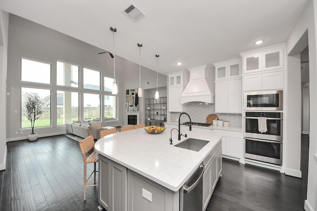 12813 N Palomino Lake Cir, Cypress, TX 77429 - kitchen featuring premium range hood, a sink, baseboards, decorative backsplash, and dark wood finished floors