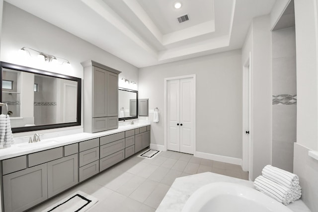 12813 N Palomino Lake Cir, Cypress, TX 77429 - bathroom with double vanity, a bathtub, a tray ceiling, and tile patterned flooring
